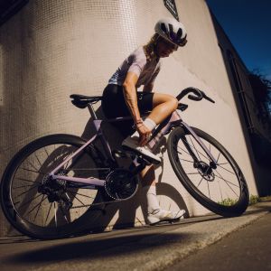 Rider on a bike adjusting her Macha Pro shoe.